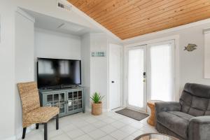 a living room with a television and a couch at Blackbird Inn in Kill Devil Hills