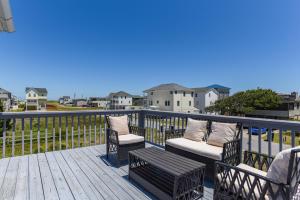 a balcony with two chairs and a bench on a deck at Blackbird Inn in Kill Devil Hills