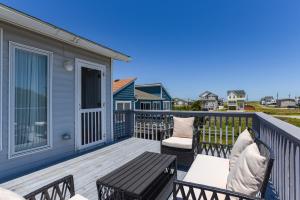a deck with two chairs and a wooden table at Blackbird Inn in Kill Devil Hills