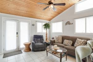 a living room with a couch and a ceiling fan at Blackbird Inn in Kill Devil Hills +18 photos
