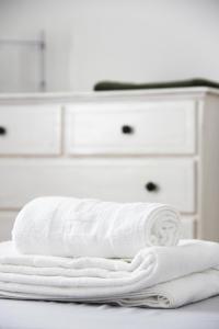 a stack of white towels on a counter in a bathroom at House9 in Kotor +52 photos