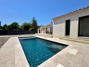 a swimming pool in front of a house at Villa Provençale in Le Thor