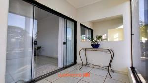 a room with a glass door and a table with a plant at Apartamento em Delfinopolis com Vista Linda in Delfinópolis