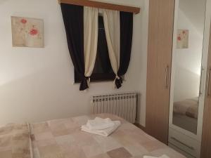 a bedroom with a bed and a window with curtains at Apartment Rosandić in Smoljanac