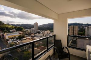 a balcony with a view of a city at Flats Diamond - Conforto, ed.novo e moderno localização impar in São Lourenço