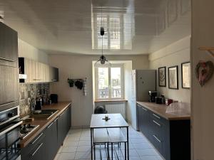 eine Küche mit einem Tisch und Stühlen darin in der Unterkunft Chez Laurette Les Montils Maison de Bourg in Les Montils
