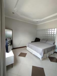 Habitación blanca con cama y TV. en Quarto Privativo Alba Star, en Belém
