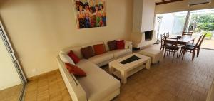 a living room with a couch and a table at Charmante maison de plain pied rénovée et climatisée en lisière de forêt in Saint-Jean-de-Monts