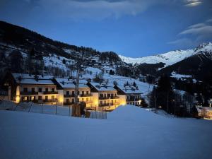 een groot gebouw in de sneeuw 's nachts bij Bellavista Alpine Home in Peio Fonti