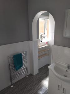 une salle de bain avec un lavabo, des toilettes et un miroir dans l'établissement Studio Twenty One, à Whitburn