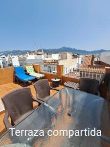 a balcony with a table and chairs on a roof at Apartamento Lola 1 in Nerja