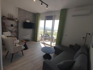a living room with a couch and chairs and a window at U laguny 404 in Shëngjin