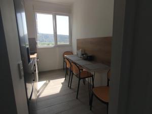 a room with a table and chairs and a window at U laguny 404 in Shëngjin
