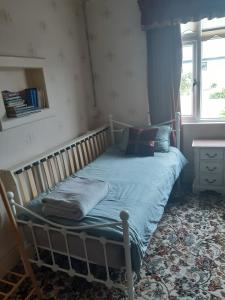 a small bed in a room with a window at Spacious 4 Bedroom House in limerick in Limerick