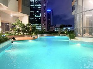 a large swimming pool in a city at night at Chevalra Luxury TRI-ZEN Apartment in Central Colombo - Galle-Face & Lotus Tower View in Colombo