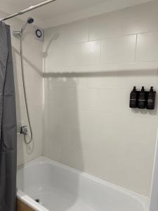 Un baño blanco con ducha y bañera. en MarDelSuites - Studio Premium Piso 14 a Pasos del Mar, Amenities, Seguridad 24hrs, Cochera Opcional, en Mar del Plata