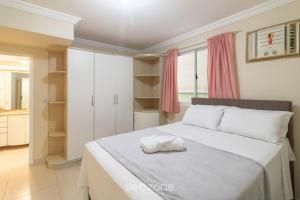 a bedroom with a bed with a towel on it at Aptos completos a passos do mar em Meia Praia – OBS in Perequê