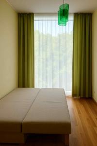a bedroom with a bed and a large window at RÜÜTLI City Center Apartment in Pärnu