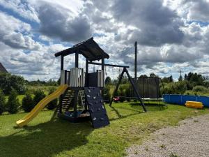 a playground with a slide in the grass at Misas loki in Cena