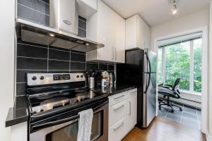 バンクーバーにあるSpacious Downtown Condo with Pool Gym & Parkingのキッチン(コンロ、冷蔵庫付)