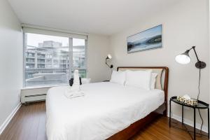 バンクーバーにあるSpacious Downtown Condo with Pool Gym & Parkingの白いベッドと大きな窓のある寝室 +19枚の写真