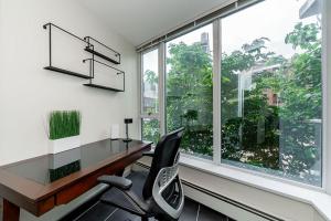 バンクーバーにあるSpacious Downtown Condo with Pool Gym & Parkingのデスクと椅子、窓のあるオフィス