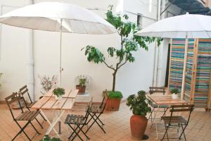 due tavoli e sedie con ombrelloni in una stanza di Casa Maplink a Roma