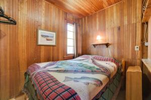 a bedroom with a bed in a wooden room at Fish, Boat and Relax Lakefront Cedarville Cabin 1 in Cedarville