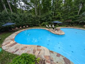 a large swimming pool with chairs and umbrellas at Ma-ple Haven --Wifi, Fireplace, Deck, Fire Pit, Family Friendly, Game Room, Pool Access in Berkeley Springs
