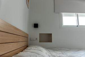 a white bedroom with a bed and a window at Feeling Doñana in Villamanrique de la Condesa