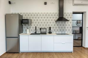a kitchen with white cabinets and a refrigerator at Feeling Doñana in Villamanrique de la Condesa +30 photos