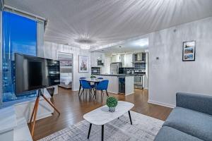a living room with a couch and a tv and a table at Downtown Condo with Great City Views in Vancouver