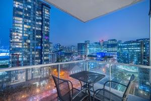 a table and chairs on a balcony with a city skyline at Downtown Condo with Great City Views in Vancouver
