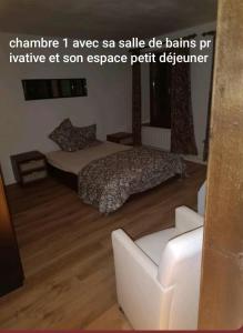 a bedroom with a bed and a white chair at La randonnée in Beaumont +14 photos