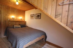 a bedroom with a bed in a wooden cabin at La Portaz in Rossinière