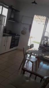 a kitchen with a table and a chair in a room at Casa com 2 quartos em condomínio in Montes Claros