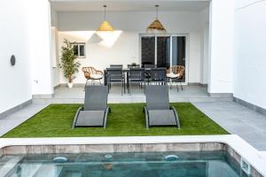 a patio with a table and chairs and a swimming pool at Feeling Doñana in Villamanrique de la Condesa