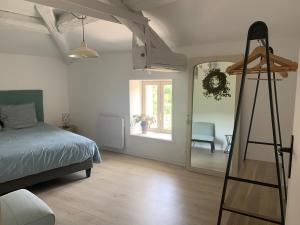 a bedroom with a bed and a ladder and a mirror at Charming house in Vergisson