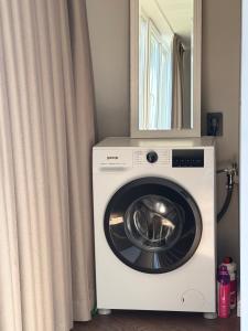 a washing machine with a mirror on top of it at Portside living in Klaipėda