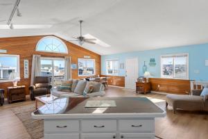a living room with a couch and a table at Coasties Ocean Breeze in Kill Devil Hills
