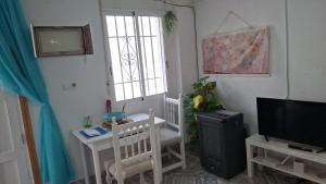 a living room with a tv and a table and a televisionicter at A Beautiful Townhouse in Rute