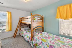 a childs bedroom with a bunk bed and yellow curtains at Color Me Beachy in Rodanthe