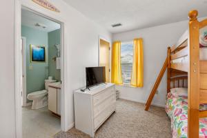 a bedroom with a bunk bed and a television on a dresser at Color Me Beachy in Rodanthe