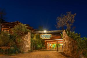 a building with a sign for a hotel at night at Pousada Maya in Alto Paraíso de Goiás