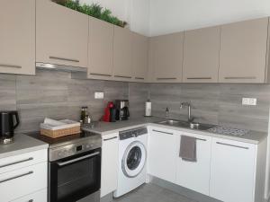 a kitchen with a washing machine and a sink at Eva Apartment in Ermoupoli