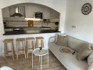 a living room with a couch and a kitchen at Ático da charca in Fisterra