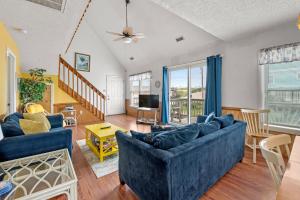 a living room with a blue couch and a table at Color Me Beachy in Rodanthe +17 photos