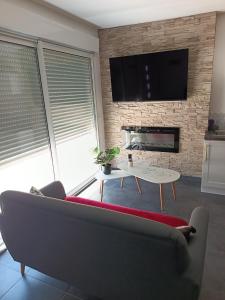 een woonkamer met een bank en een open haard bij Évasion romantique avec jacuzzi intérieur in Rosières-près-Troyes