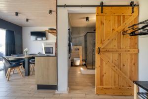 a sliding barn door opens up a kitchen and dining room at Porzeczkowe domki in Darłowo