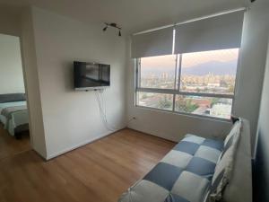 a room with a tv and a bed and a window at Departamento completo 2 dormitorios 1208 cercano movistar arenas in Santiago